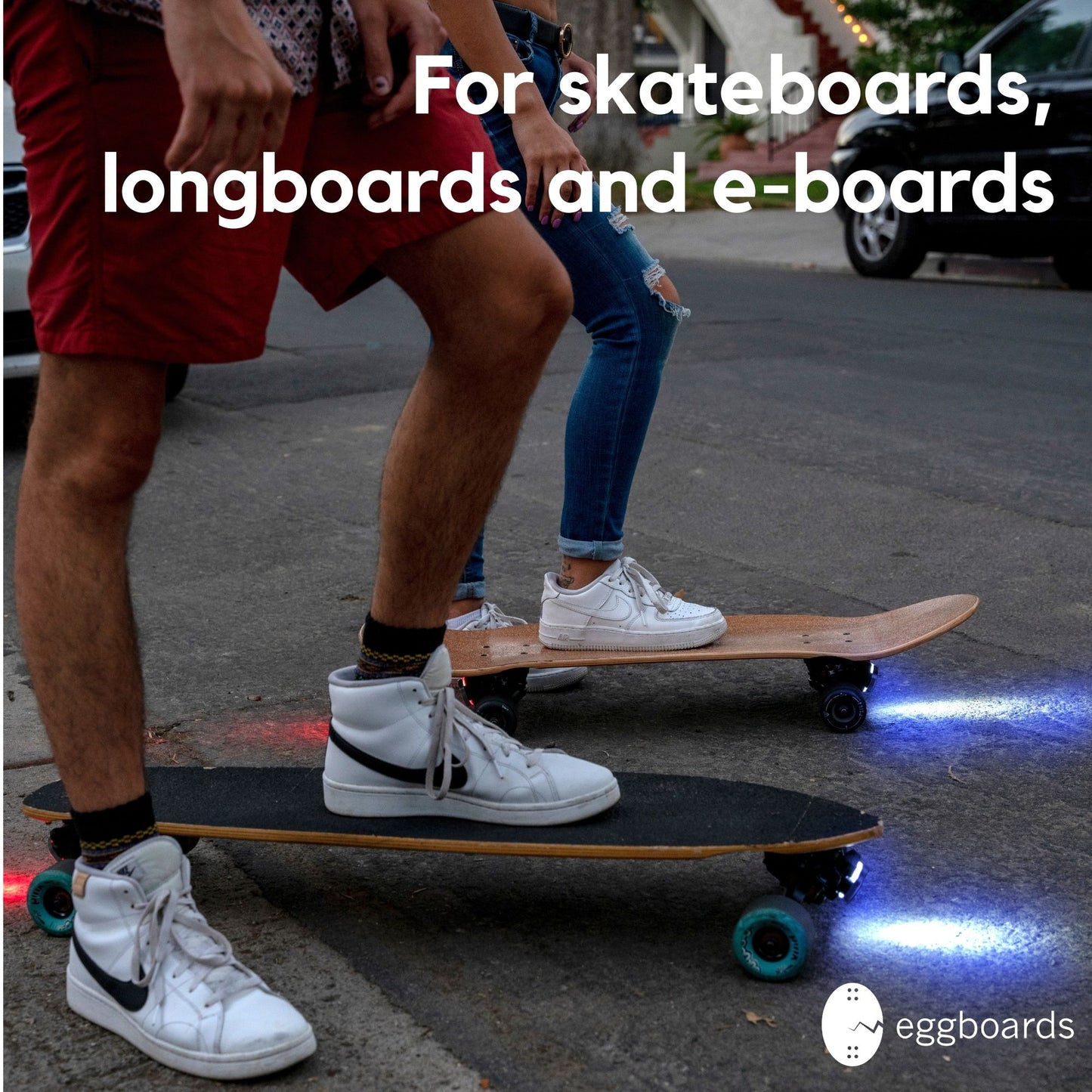 Two skaters aligned and ready to ride at night, showcasing their Blue-Red LED skateboard lights for maximum visibility and style.