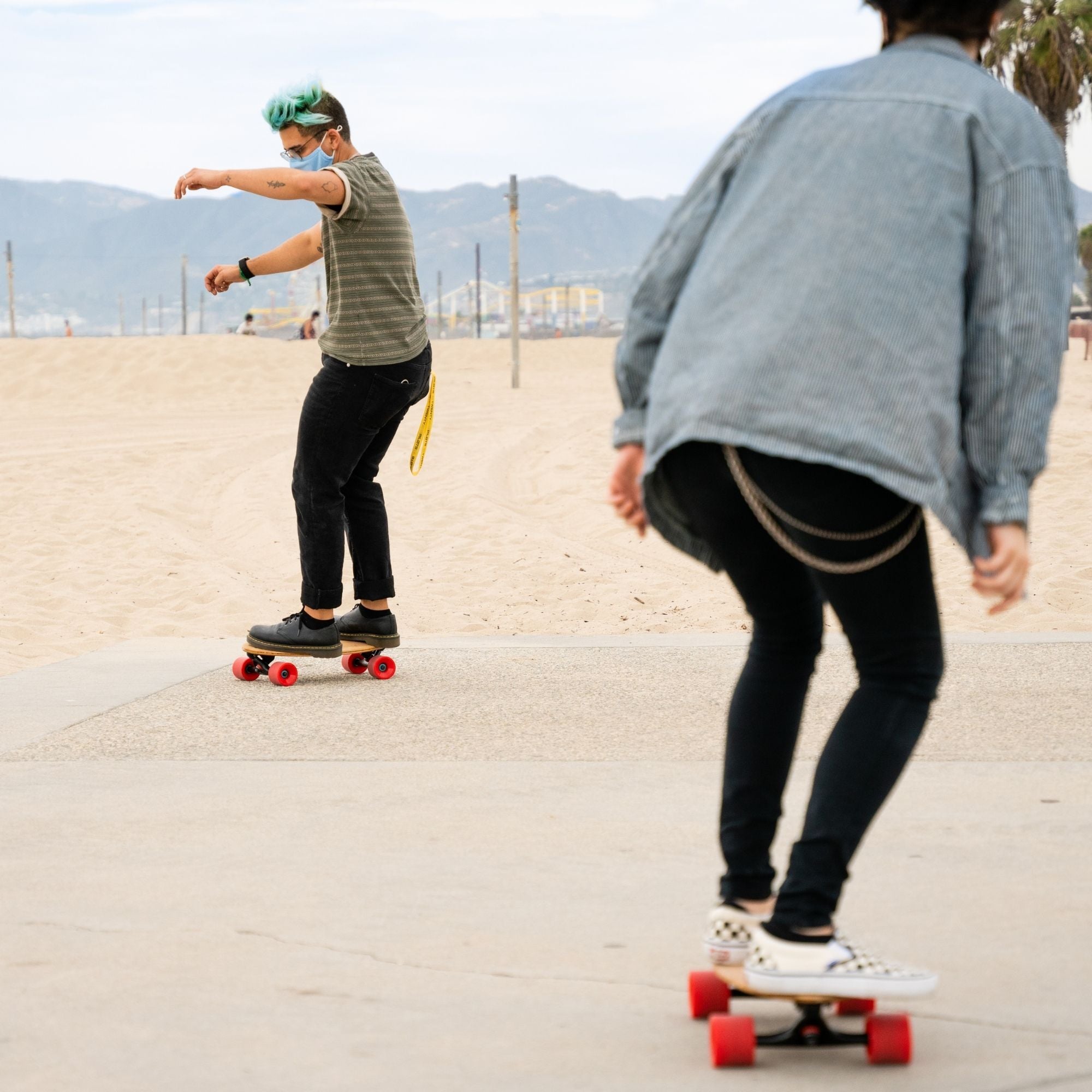 Two skaters riding Eggboard mini cruiser skateboards along the beach in Venice, California, enjoying a sunny day. The scene captures the fun and freedom of skateboarding, highlighting the stylish design of these cruiser skateboards and the beach atmosphere.