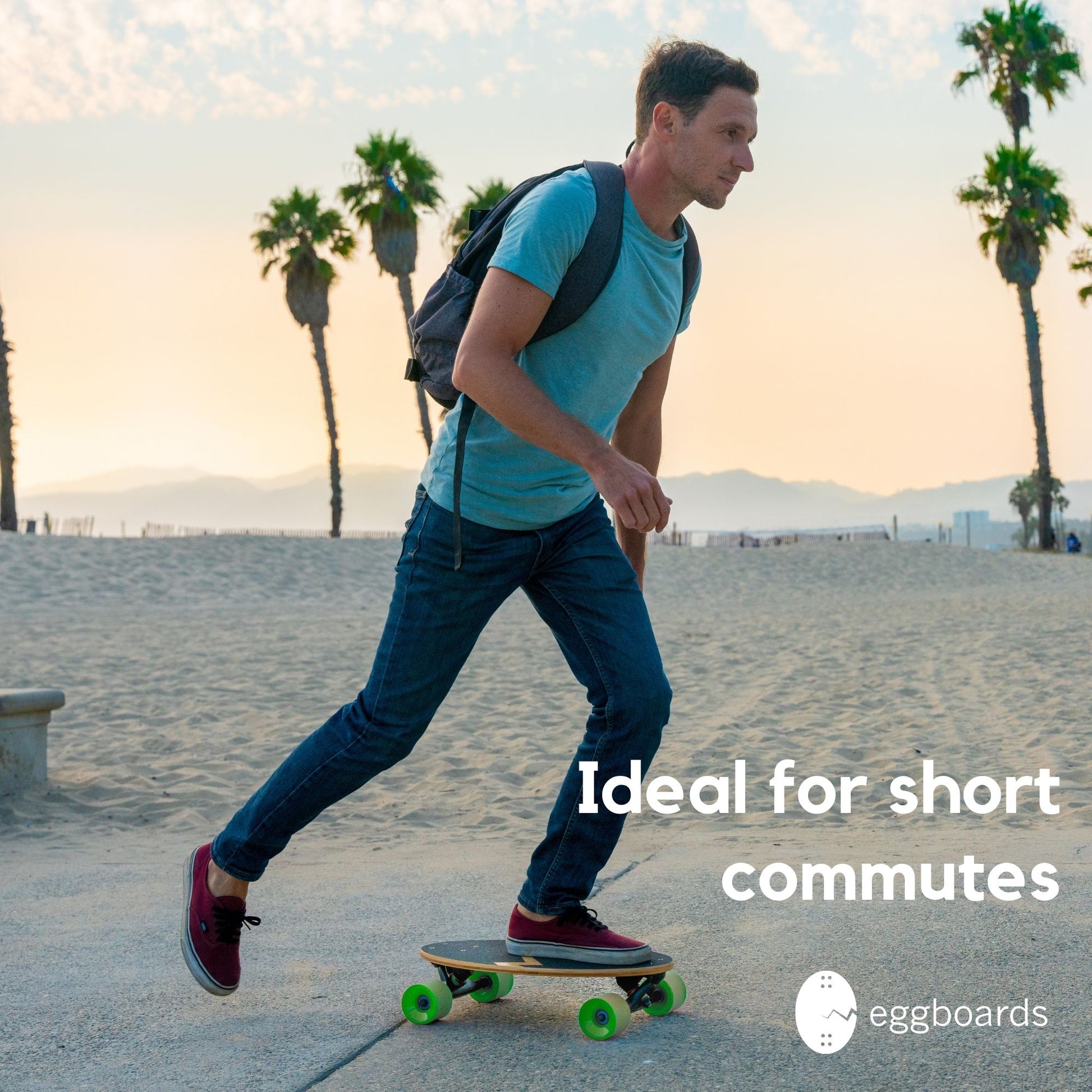 A guy with a backpack skateboarding on an Eggboard mini longboard with green wheels by the beach in Venice, California, featuring palm trees in the background. The overlay text reads "ideal for short commutes.