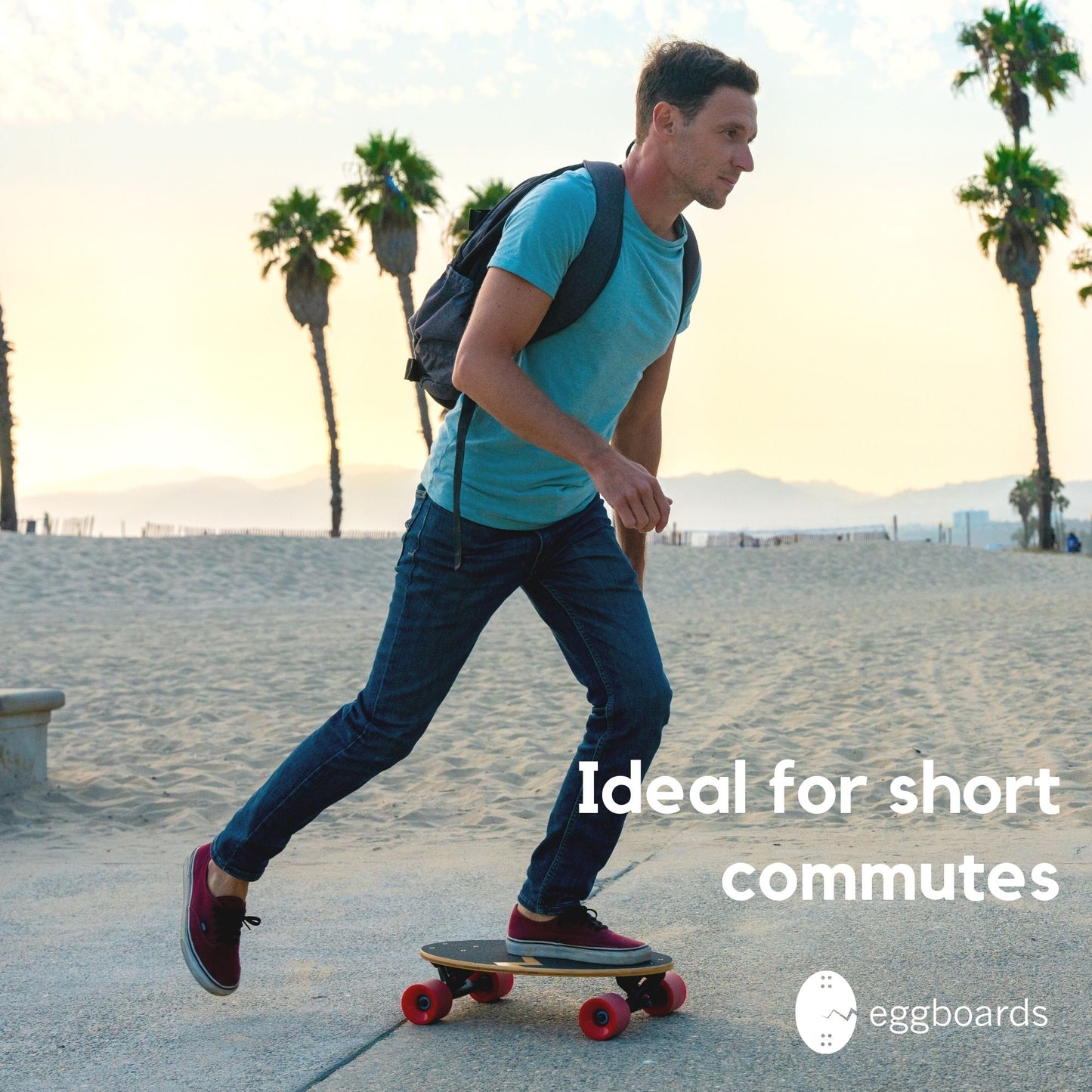 A skater with a backpack riding an Eggboard Mini Longboard by the beach in Venice, California, with palm trees in the background, showcasing the board's suitability for urban adventures and coastal cruising.