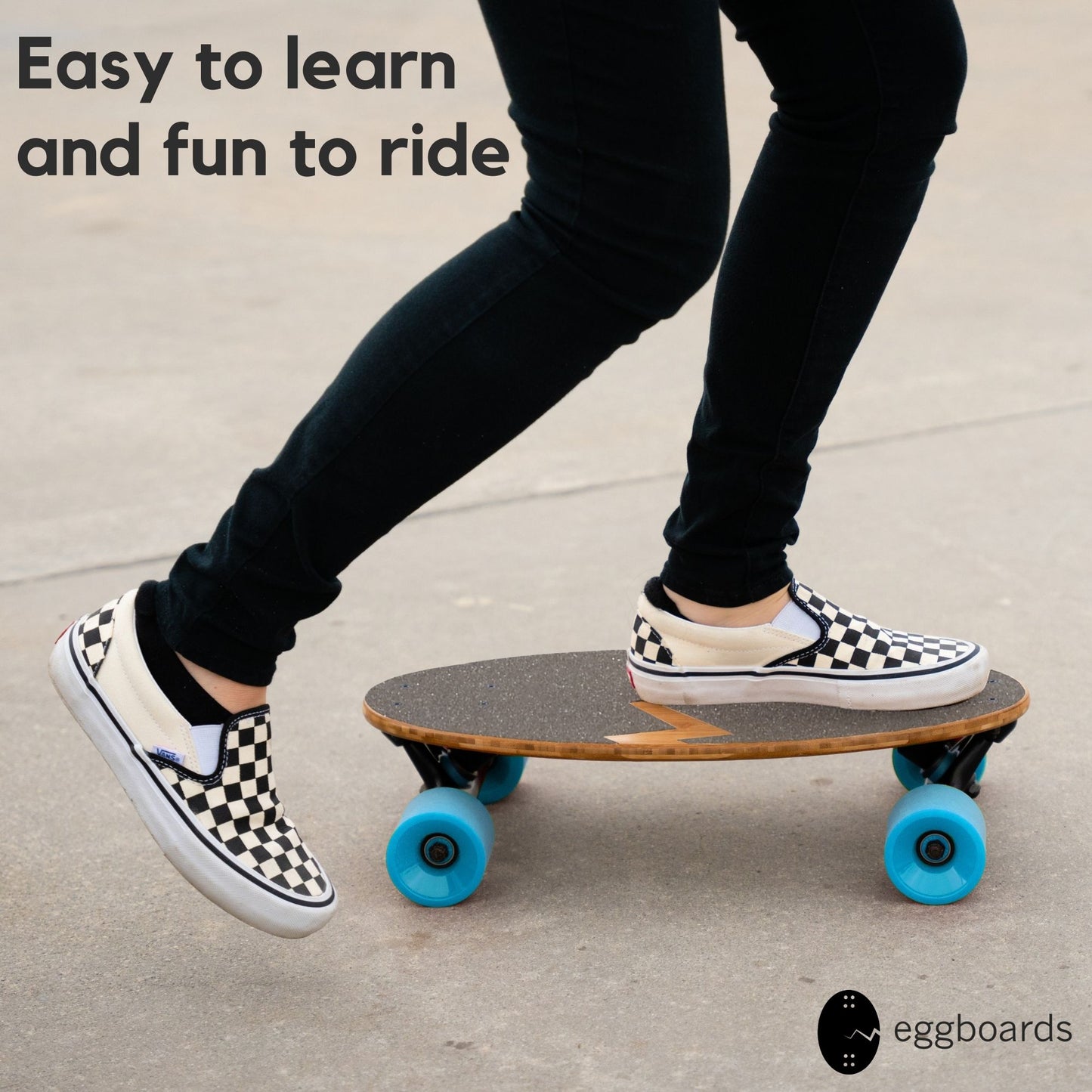 Closeup of a girl with checkered Vans shoes riding an Eggboard mini longboard cruiser with blue wheels. The overlay reads "Easy to Learn and Fun to Ride," emphasizing the board's user-friendly design for beginners and experienced riders alike.